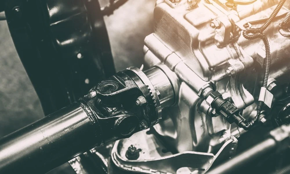Close-up of automotive engine components showing metal pistons, cylinders, and mechanical parts in sepia tones