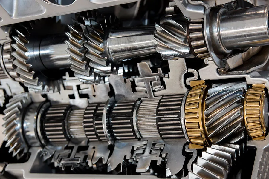 Cross-section view of automotive transmission gearbox showing multiple gear teeth, shafts, and bronze synchro rings