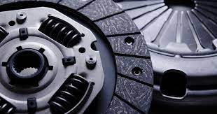 Close-up view of automotive clutch disc components showing friction material, springs, and metal housing parts