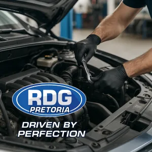 Mechanic in black gloves performing engine service under open car hood at PDG Pretoria automotive shop